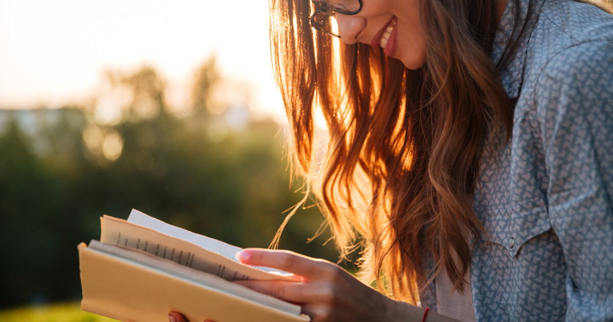 Frau mit Brillen liest das Buch im Park
